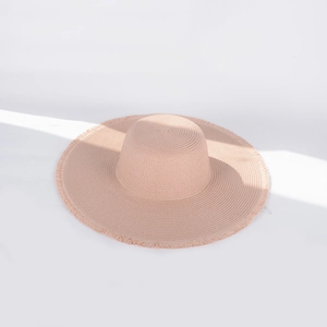 Detail of light pink wide brim straw hat with fringe edge and sun shadow effect
