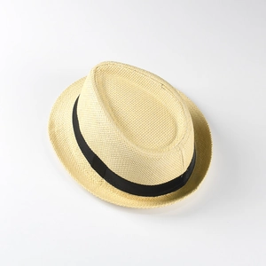Gros plan d'un chapeau de paille pour enfants avec texture tissée et ruban noir