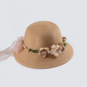 Dettaglio cappello di paglia con fiori 3D e nastro di seta rosa chiaro per donna