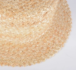 Vue macro détaillée du tissage serré en paille de blé naturelle du chapeau à bord plat