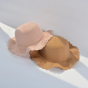 Close-up of woven straw hats featuring scalloped wavy edges and elegant spiral textures