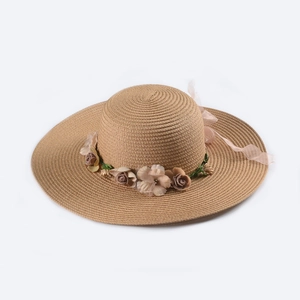 Detailed view of straw sun hat featuring woven spiral texture and fabric rose ribbon