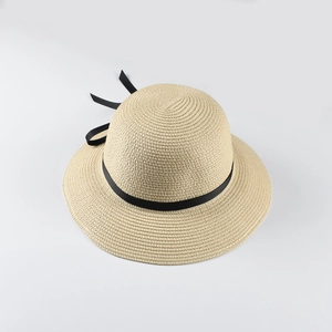 Detailed close-up of woven beige sun hat with an elegant black ribbon bow detail
