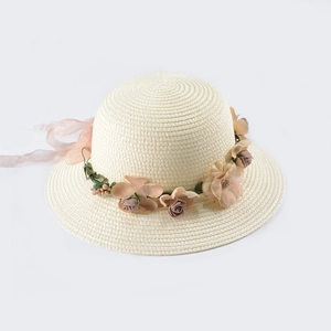 Dettaglio cappello di paglia crema con fiori di raso 3D e nastri in chiffon rosa chiaro