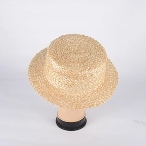 Détail du tissage en paille de blé naturelle sur un chapeau canotier à bord plat