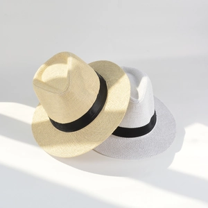 Detail of light beige and white paper woven straw hats with elegant black ribbons