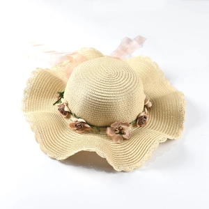 Women's straw sun hat with large wavy brim and floral ribbon for beach vacations