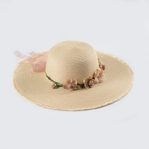Detail of summer straw hat featuring pastel floral ribbon and fringe brim for vacation