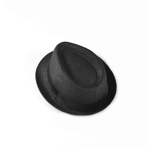 Détail de la texture tressée et du ruban noir sur un chapeau de paille pour enfants
