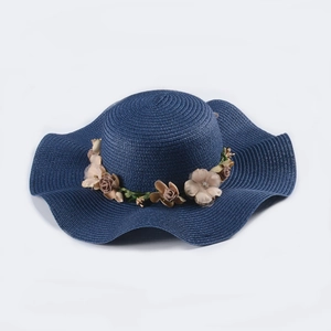 Navy blue wide brim sun hat with woven spiral pattern and elegant floral decoration