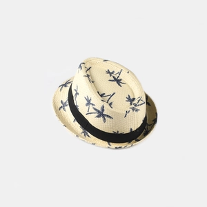 Detail of light beige woven Panama hat featuring navy blue palm tree prints and black ribbon