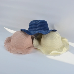 Detail of colorful children straw hats with unique wavy edges in studio setting