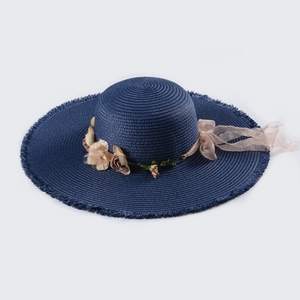 Detail of navy straw sun hat with floral mesh bow and natural tassel edges