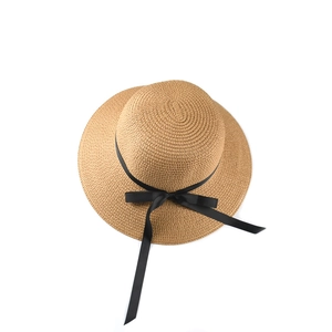 Detailed view of woven straw hat featuring fine texture and elegant black satin ribbon bow