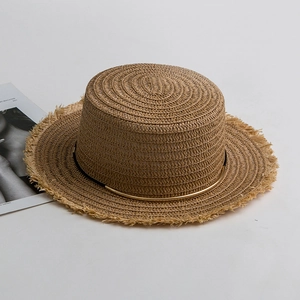 Detail of flat top straw hat featuring raw frayed edges and golden metal band decoration