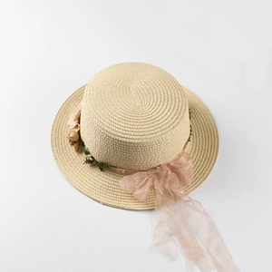Top-down view of straw sun hat with floral wreath and pink organza ribbon details