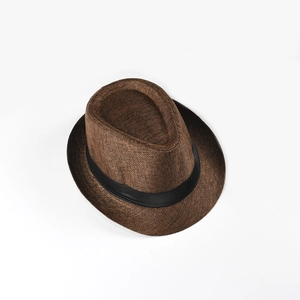 Detail of dark brown woven fedora hat featuring a classic black ribbon band and fine texture