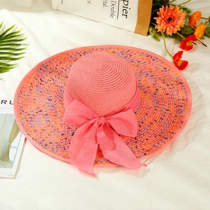 Pink wide brim straw sun hat with colorful accents and large ribbon for summer travel