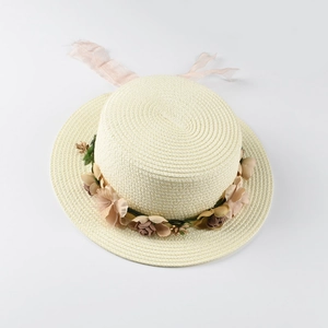 Detailed view of handmade boater straw hat featuring floral wreath and pink silk ribbons