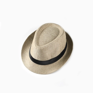 Detailed close-up of woven texture and black ribbon band on a summer straw jazz fedora hat
