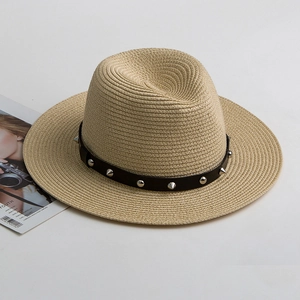 Close-up of woven fedora hat with black leather band featuring silver punk metal studs