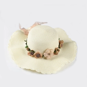 Beige wide brim straw hat with floral trim and wavy edges for summer beach vacations