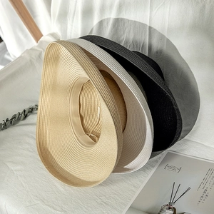 Detailed texture of foldable straw sun hats in beige, cream, and black colors