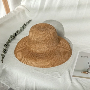 Flat lay of a wide-brimmed brown straw hat with fine weave texture for sun protection