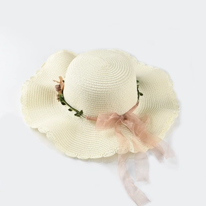 Detail of beige straw hat with floral vine trim and translucent organza ribbon bow
