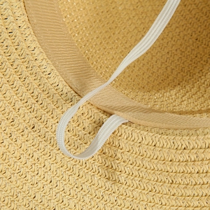 Detail view of woven straw hat interior featuring a grosgrain sweatband and elastic chin strap
