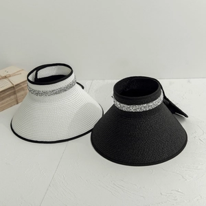 Detailed texture of straw weave sun visor with sparkling rhinestones and chic bow tie