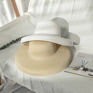 Detail of woven straw texture on beige and white wide-brim sun hats for beach travel