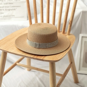 Detail of summer boater straw hat featuring a sparkling rhinestone decorative band