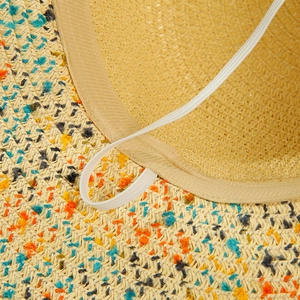 Detailed view of straw hat interior with sweatband, woven fibers and elastic wind strap