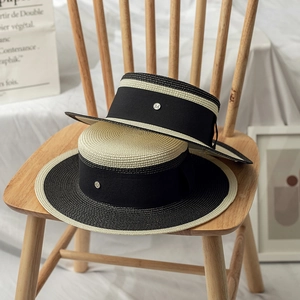 Flat top boater straw hat with black and beige stitching and metal M logo band