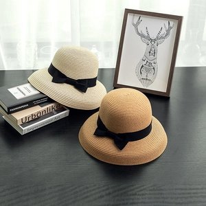 Straw sun hats with black ribbon bows for women in beige and khaki for summer travel
