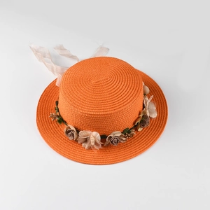 Detail of flat-top straw hat with orange woven texture and elegant silk floral band