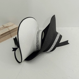 Detail view of woven sun hats with silver sequin bands and satin bow accents