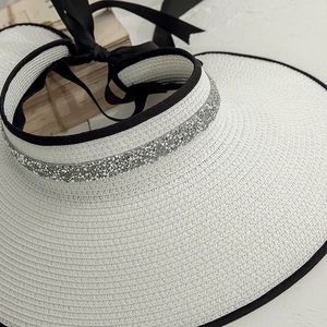Detailed view of sun visor hat with silver rhinestone trim and black satin bow