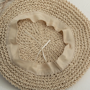 Détail intérieur du béret en paille avec cordon réglable et bande de confort en tissu