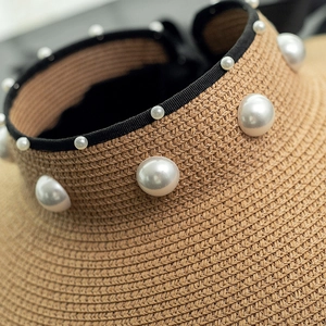 Detailed macro view of woven straw texture with elegant white pearls on a sun hat
