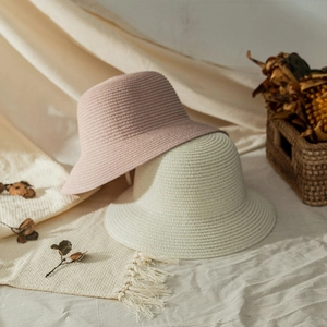 Close-up of knit texture on pink and beige straw sun hats for baby girls beach travel