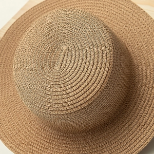 Close-up of the fine spiral woven texture on a natural straw boater sun hat crown