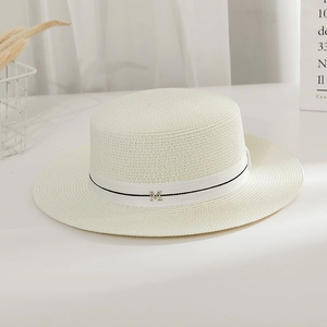 Detailed texture of flat top straw boater hat with white ribbon and metal M emblem