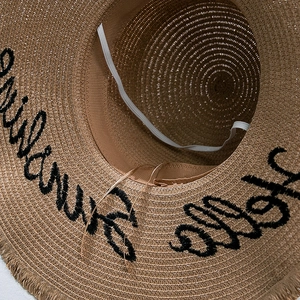 Détail d'un chapeau de paille brodé avec doublure et cordon coupe-vent élastique réglable