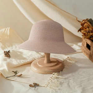 Detailed view of the fine woven texture on the foldable beige straw sun hat for girls