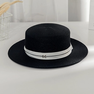 Chic black boater straw hat with wide white ribbon and silver M logo for beach vacation