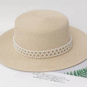 Detailed texture of woven straw boater hat with multi-layer pearl beaded band decoration