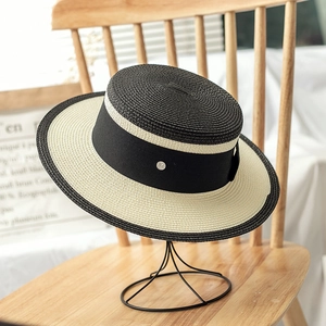 Flat top straw boater hat with black and white color blocking and M metal detail