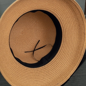 Detail of hand-woven straw hat interior with adjustable black sweatband and tie